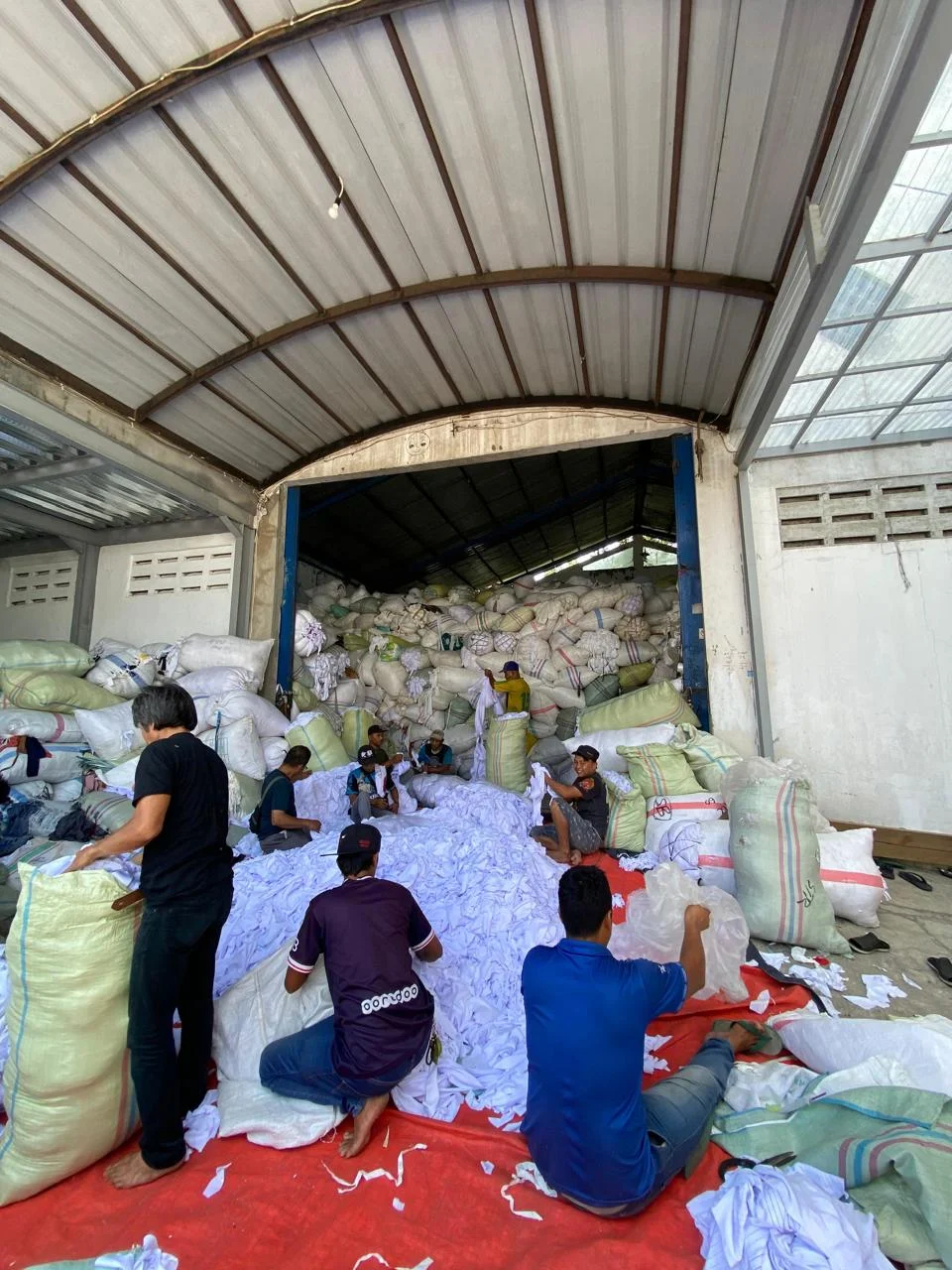 Karyawan F2N melakukan sortir material tekstil di gudang